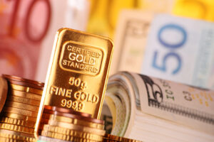 Composition with 50 gram gold bar, banknotes and coins.